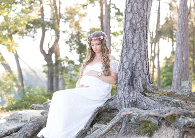 Zauberhafte Babybauchfotografie im Aalener Wald mit Spitzenkleid und Blumenkranz