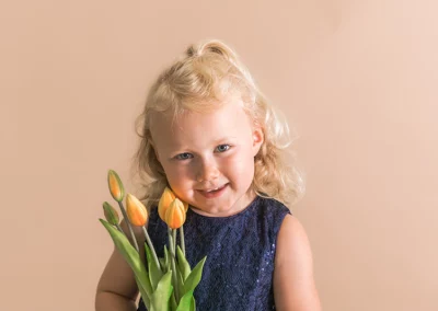 Zauberhaftes Kindergartenfoto eines Mädchens mit Blumen im Fotostudio